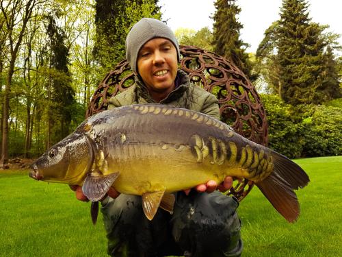 a man holding a large fish in his hands at Kromven in Merksplas
