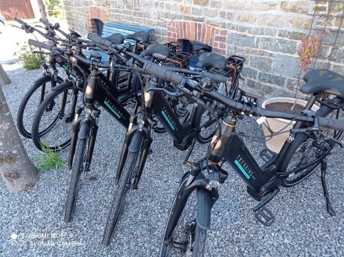 een rij fietsen geparkeerd naast een bakstenen muur bij L'ancienne Boulangerie in Durbuy