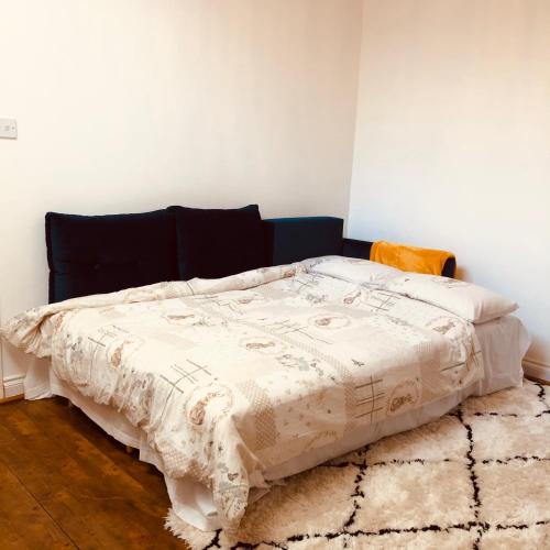 a bedroom with a bed with a blanket on it at Whiteley's Cottages in Dumbarton