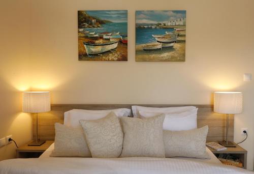 una camera da letto con un letto e due dipinti alle pareti di Family Houses Keramoti a Keramotí