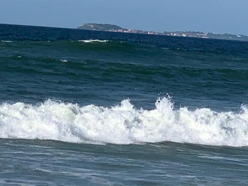 a small wave in the ocean on the water at MBAO Sipres Appartement moderne bord de mer in Mbaw