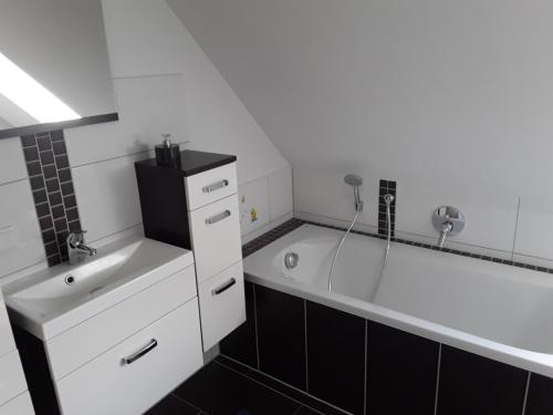 a bathroom with a large tub and a sink at Landhaus Waldblick in Kritzow
