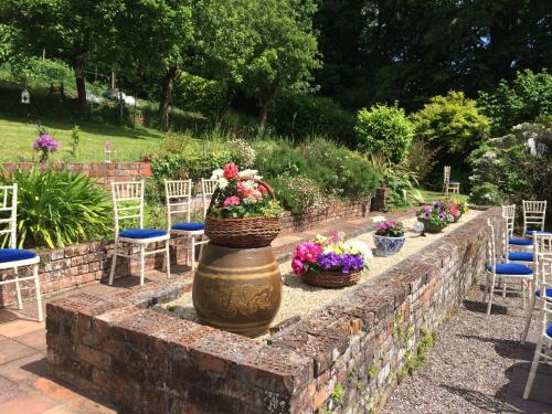 a stone wall with baskets of flowers and chairs at Flemings Country House in Cork