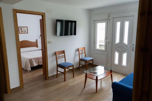 a living room with a bed and a table and chairs at Casa Area da Vila in Camariñas