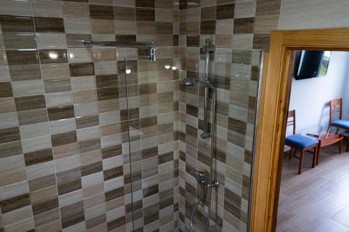 a bathroom with a shower with a glass door at Casa Area da Vila in Camariñas