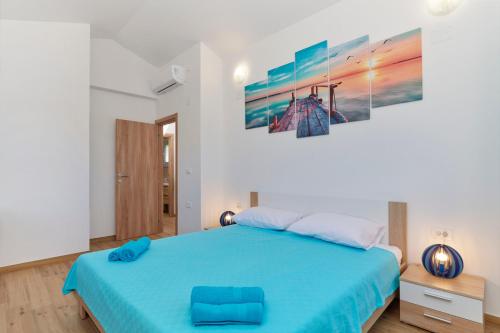 普拉的住宿－Apartment Olivix，卧室配有蓝色的床和墙上的绘画作品