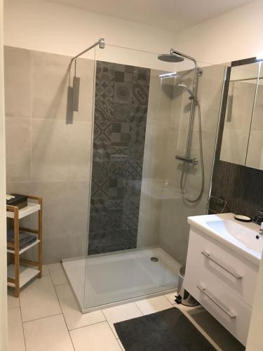 uma casa de banho com um chuveiro e um lavatório. em Appartment in Kammerl em Schörfling