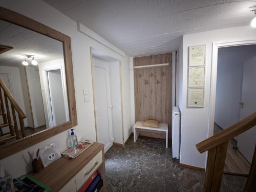 a bathroom with a sink and a mirror and a door at Szarvaskő Vendégház in Szarvaskő