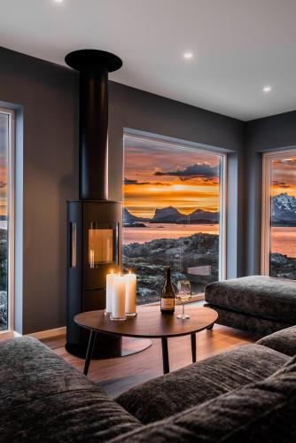 a living room with a fireplace and a table with candles at Lofoten SeaZens Panorama in Leknes