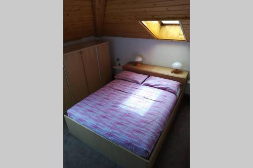 a small bed in a small room with a window at Casa bianca in Malè