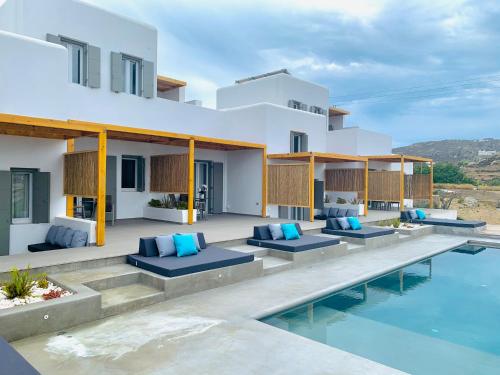a villa with a swimming pool and a house at CASA DI PIETRA MYKONOS in Klouvas