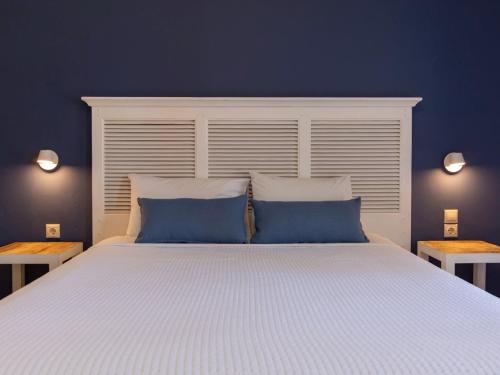 a bedroom with a large bed with two blue pillows at FiscardoStudios in Fiskardho