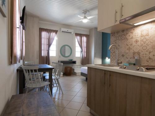 a kitchen with a sink and a table with chairs at FiscardoStudios in Fiskardho