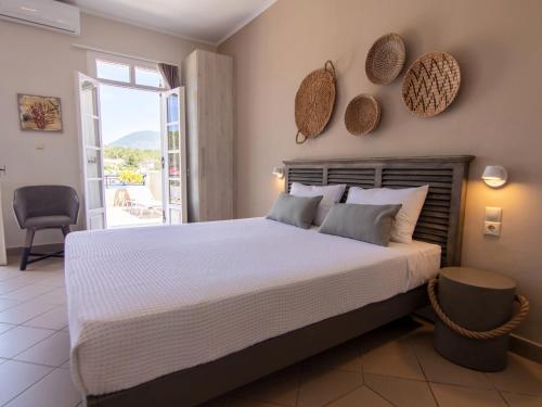 a bedroom with a large bed and a balcony at FiscardoStudios in Fiskardho