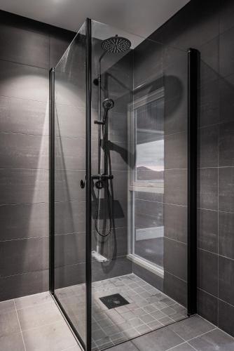 a shower with a glass door in a bathroom at Lofoten SeaZens Panorama in Leknes