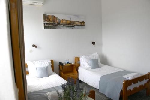 a bedroom with two beds and a painting on the wall at Klinakis Beach Hotel in Chania Town