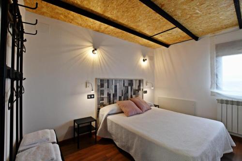 a bedroom with a white bed and a chair at RuralesTeruel punto com in Teruel