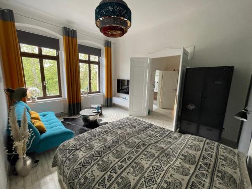 ein Schlafzimmer mit einem großen Bett und einem blauen Sofa in der Unterkunft DESIGN Apartment II - 45qm Grenze Altstadt Park in Görlitz