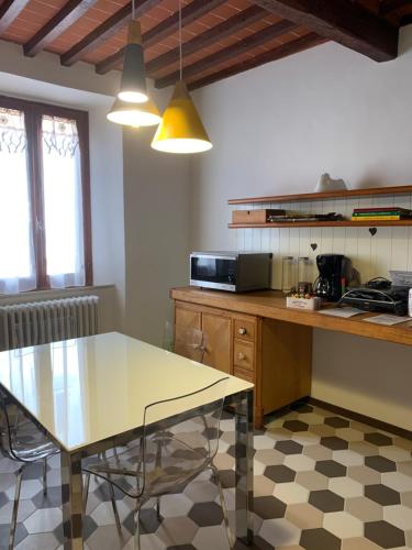 eine Küche mit einem Tisch und einer Arbeitsplatte in der Unterkunft Fonte alle Ninfe B&B in Castiglione dʼOrcia