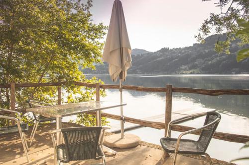 a table and an umbrella and chairs on a dock at Centro Magliaso in Magliaso