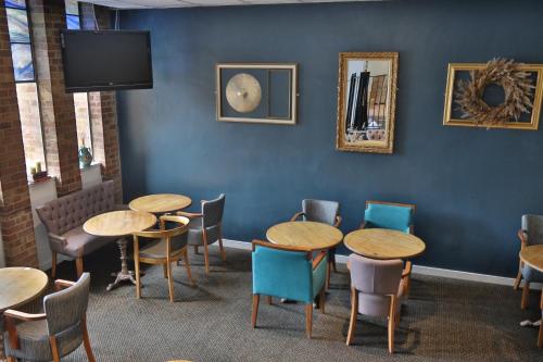 a room with tables and chairs and a tv at Inn On The Lake in Gravesend