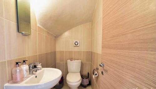 a bathroom with a white toilet and a sink at Protaras Ionian Breeze House in Paralimni