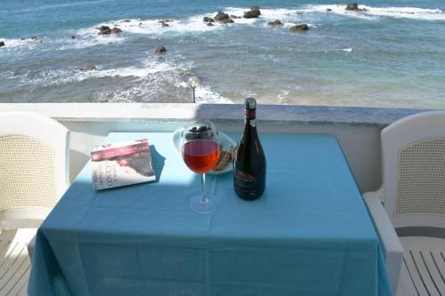 a blue table with a bottle of wine and a glass at Klinakis Beach Hotel in Chania Town