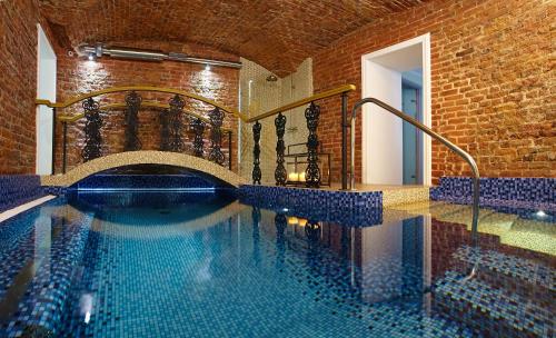 a swimming pool in a building with a brick wall at Rossi Boutique Hotel in Saint Petersburg