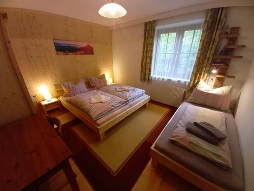 a small bedroom with two beds and a window at Appartement IVA in Flattach