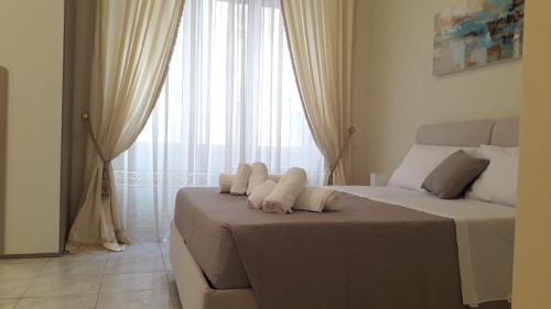 - une chambre avec un grand lit et des serviettes dans l'établissement Sweet Home Agropoli, à Agropoli