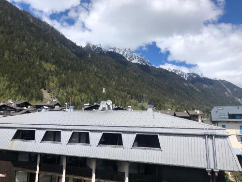 a roof of a building with a mountain in the background at Studio lumineux neuf dans l'hyper centre avec vue in Chamonix