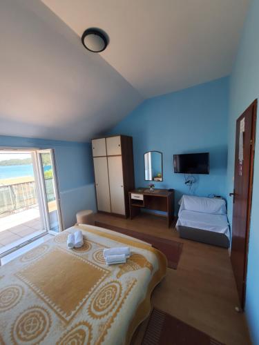 a blue room with a bed and a window at Apartments Dabelić in Polače