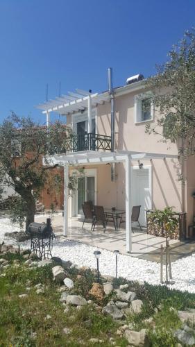 a house with chairs and a patio in front of it at Oikies in Prinos