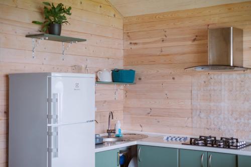 a kitchen with a white refrigerator and wooden walls at Sidari in Auleja