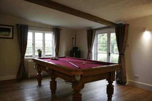 um quarto com uma mesa de bilhar num quarto com janelas em Church Farmhouse, Surrey, Sleeps 10, Large Garden em Crowhurst