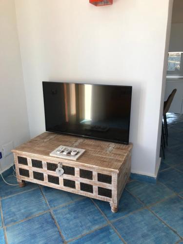 Une télévision à écran plat est installée au-dessus d'une table en bois. dans l'établissement Le Suite Guarinelli B&B, à Gaète