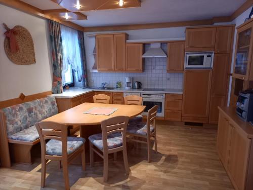 - une cuisine avec une table et des chaises en bois dans l'établissement Appartement IVA, à Flattach