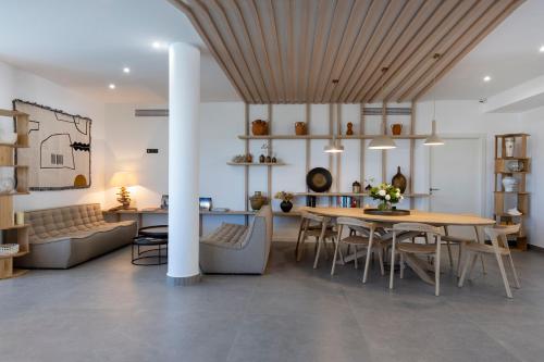 a dining room and living room with a table and chairs at Hotel L'Acquale in Calvi