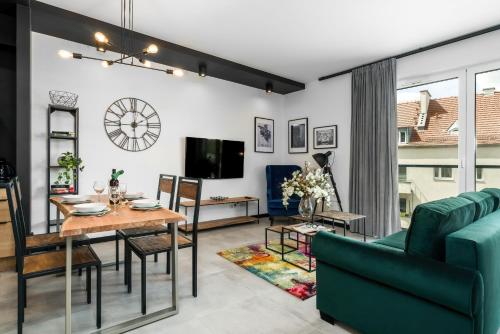 een woonkamer met een groene bank en een tafel bij Apartments Poznań Chwaliszewo Residence with FREE GARAGE by Renters in Poznań