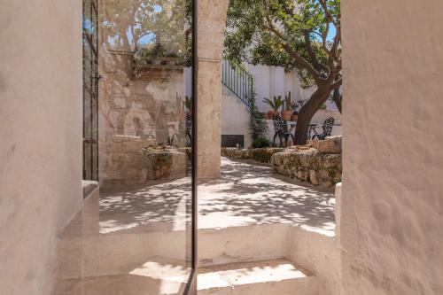 a glass door on a building with a sidewalk at Il Sogno delle Benedettine in Ostuni