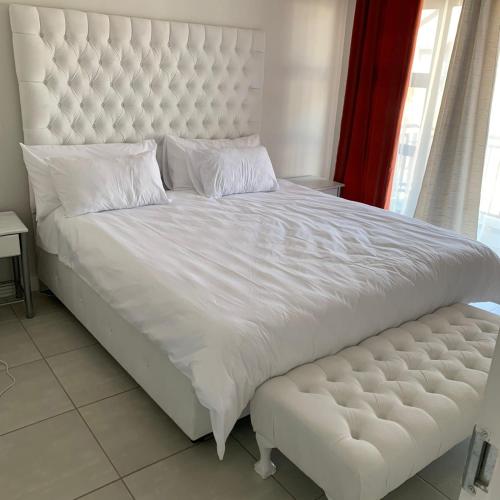 a large white bed with a large white headboard at THE BLYDE CRISTAL LAGOON in Pretoria