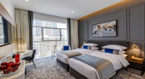 Cette chambre comprend 2 lits et une fenêtre. dans l'établissement Rose Executive Hotel - DWTC, à Dubaï