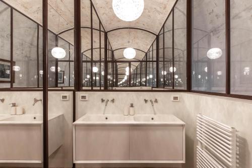a bathroom with two sinks and two mirrors at Il Sogno delle Benedettine in Ostuni
