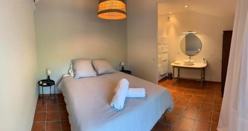 una camera da letto con un letto con asciugamani sopra di Mas de la Pivoine a Le Puy-Sainte-Réparade