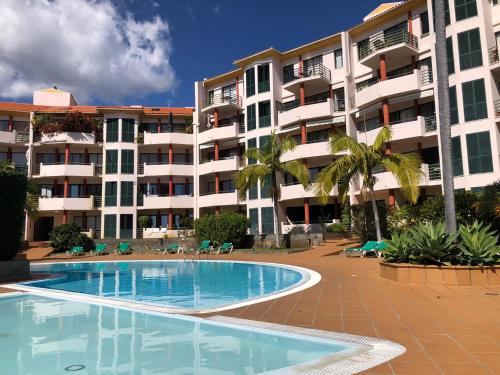 a swimming pool in front of a large apartment building at Varandas do Funchal in Funchal