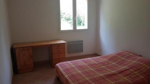 1 dormitorio con cama, escritorio y ventana en Rez de villa, en Le Beausset