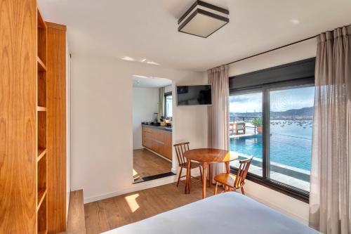 a bedroom with a table and a view of the water at Ioda Guesthouse in Arraial do Cabo