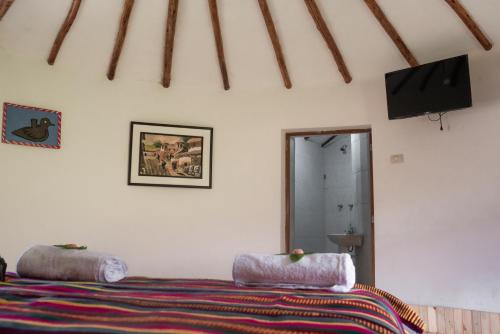 a bedroom with a bed and a flat screen tv at Tullpa Rumy in Yungay