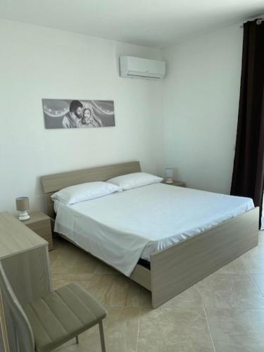 a bedroom with a bed and a chair in it at Tus'Hotel in Castel di Tusa