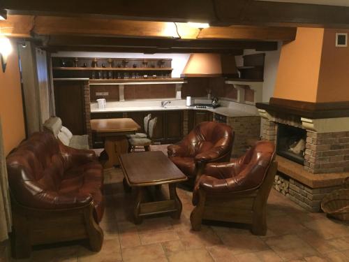 a living room with leather chairs and a fireplace at RRR Apartmány 1 in Bojnice